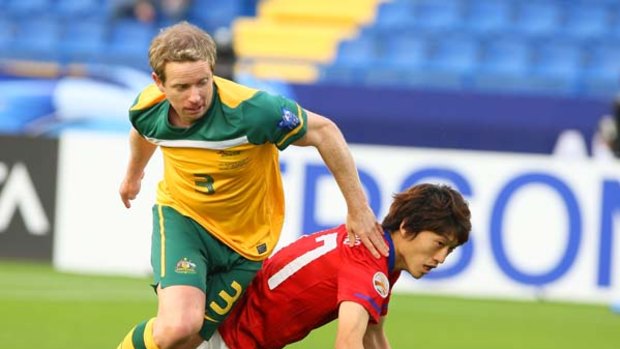 South Korea's player Lee Chung Yong, is tackled by Australia's David Carney.