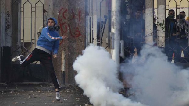 A student of Al-Azhar University, who is a supporter of the Muslim Brotherhood and deposed President Mohamed Mursi, throws a stone during clashes with riot police and residents.