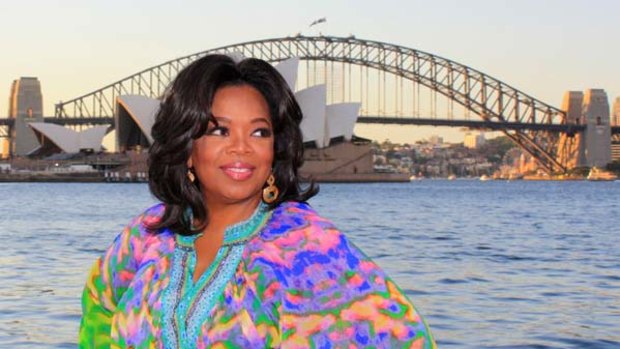 American talk show queen Oprah Winfrey poses in front of the Sydney Harbour Bridge and the Opera House.