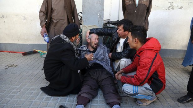 A distraught man is cared for outside a hospital following a suicide attack in Kabul, Afghanistan, on Thursday.