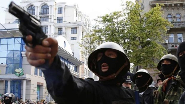 A pro-Russian activist aims a pistol at supporters of the Kiev government during clashes in the streets of Odessa.