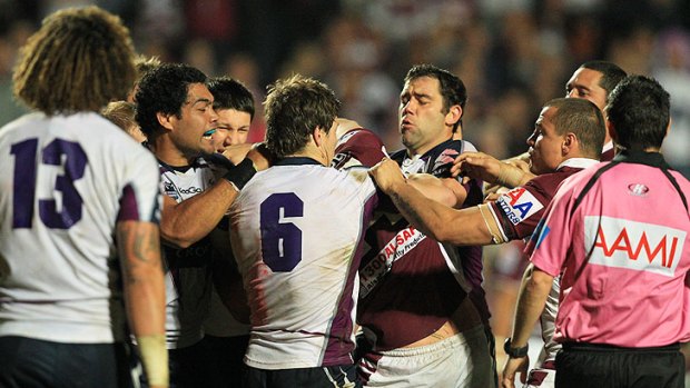 Stormy night: Melbourne and Manly players slug it out at Brookvale Oval on Friday during the Sea Eagles' 18-4 victory.