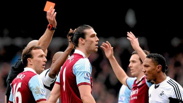 Legal challenge: West Ham United's English striker Andy Carroll (centre) is sent off by referee Howard Webb after challenging Swansea City's Spanish defender Chico Flores.