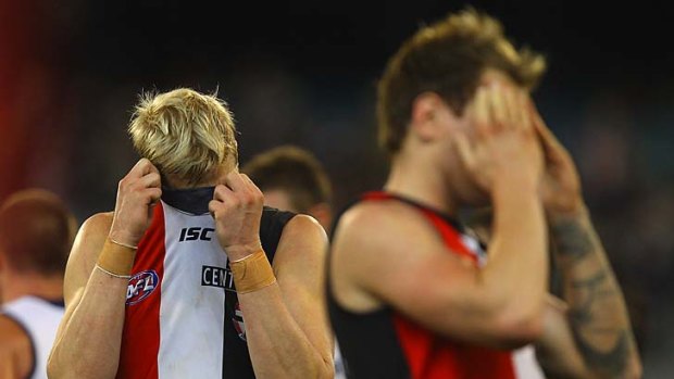 A dejected Nick Riewoldt hides his face after the Saints lost to Geelong. On the right is an equally disappointed Jason Gram.