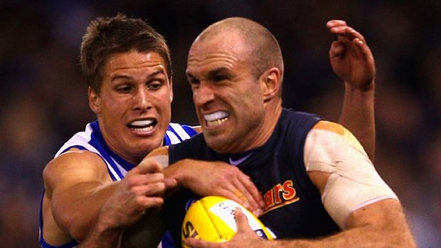 Chris Judd tenses up in anticipation as Andrew Swallow approaches to lay a tackle