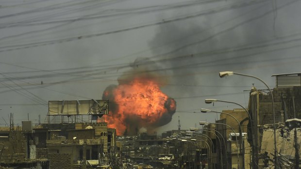 A fireball explodes in the air above the shattered streets of west Mosul on July 3.