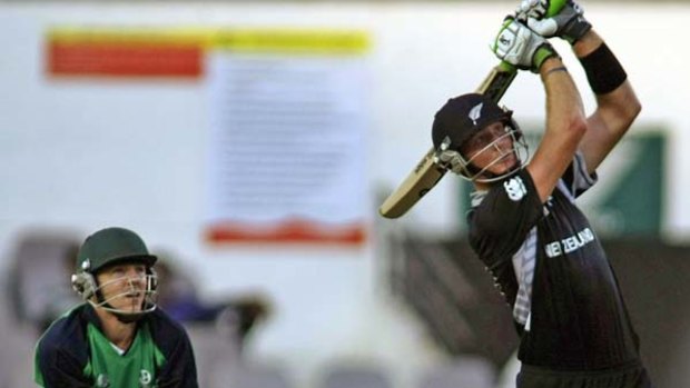 Martin Guptill hits a six as he top scores for New Zealand.