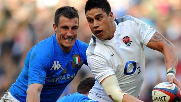 England's centre Shontayne Hape looks to pass the ball as he gets tackled by Italy's scrum half Fabio Semenzato.