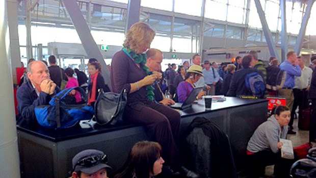 Virgin Blue passengers wait at Sydney Airport this morning.