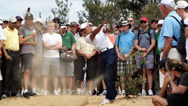 Popular ... fans watch Tiger Woods chip out of the sand.