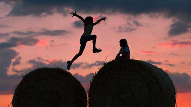 Two children play on bales of straw in Petersdorf, eastern Germany, where the sun sets behind a red-colored sky. <i>Picture: AFP</i>