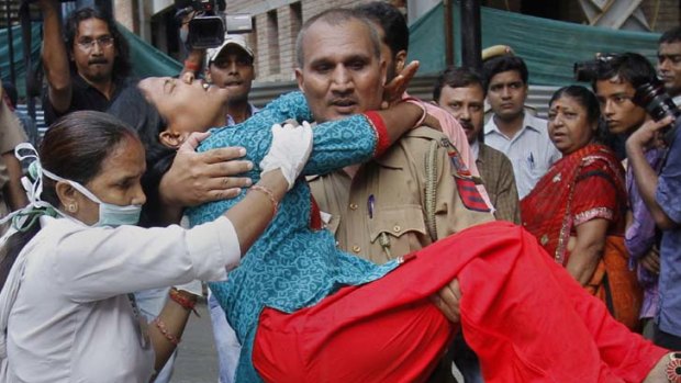 Another victim ... a policeman carries a wounded woman from the blast site outside the High Court in Delhi.
