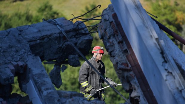 Emergency workers search the rubble of a building.