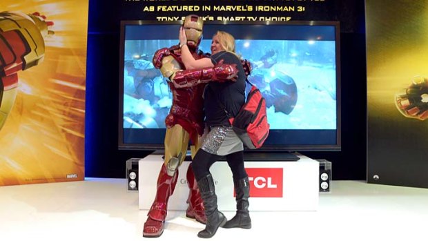 A woman kisses Iron Man at the TCL booth at the Consumer Electronics Show in Las Vegas.