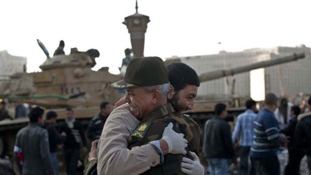 Singing, cheering and dancing on the streets of Cairo ... a civilian and an army commander embrace in Tahrir Square after Egyptians forced Hosni Mubarak to resign on Saturday.