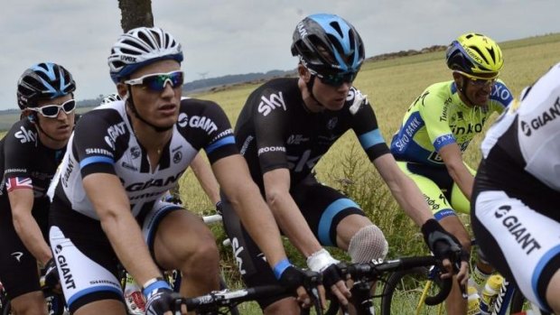 Patched up: Chris Froome, with a bandaged knee, rides near the back of the field after his fall.