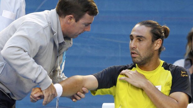 Fizzer . . . Injury forces Marcos Baghdatis to retire from the much-hyped third-round clash against Lleyton Hewitt.