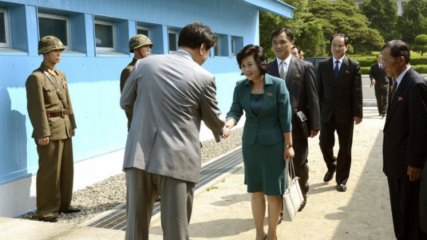 Kim Song Hye, center, the head of North Korea's delegation, shakes hands with an unidentified South Korean officer before crossing a military demarcation line, which has separated the two Koreas since the Korean War, for a meeting with South Korean delegates at Panmunjom in Paju, north of Seoul, South Korea.