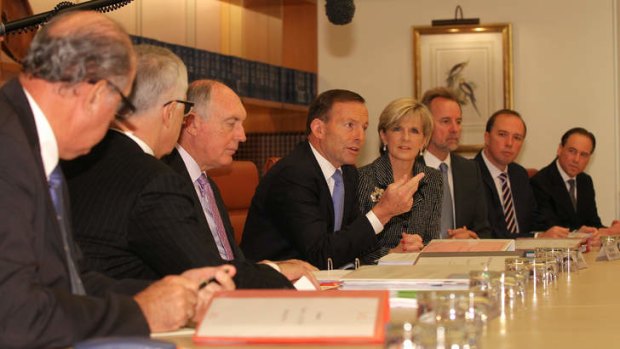 Prime Minister Tony Abbott address colleagues in a cabinet meeting. He has said that repealing the carbon tax is the priority for the government in negotiations with the incoming Senate.
