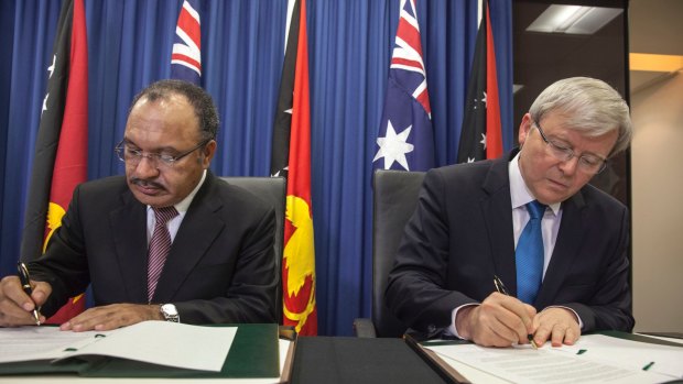 Papua New Guinea's Prime Minister Peter O'Neill and Kevin Rudd sign an agreement over asylum seekers in July 2013.