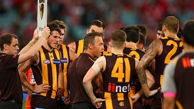 Hawks coach Alastair Clarkson with players during a break.