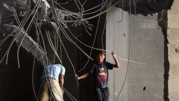 Bombarded ... Palestinians survey the bomb damage to a Hamas building in Gaza City.