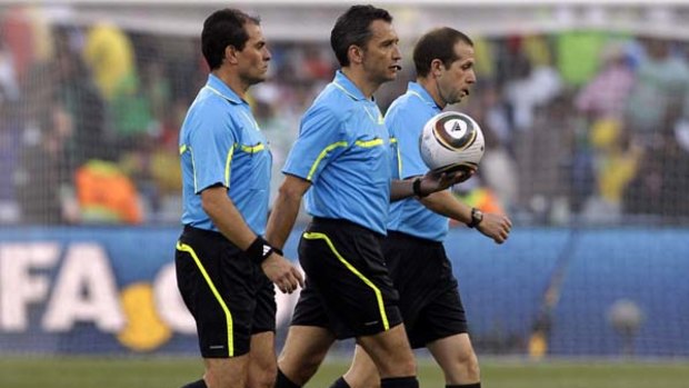 Under the spotlight ... referee Jorge Larrionda, centre, accompanied by assistant referees Pablo Fandino, left, and  Mauricio Espinosa.