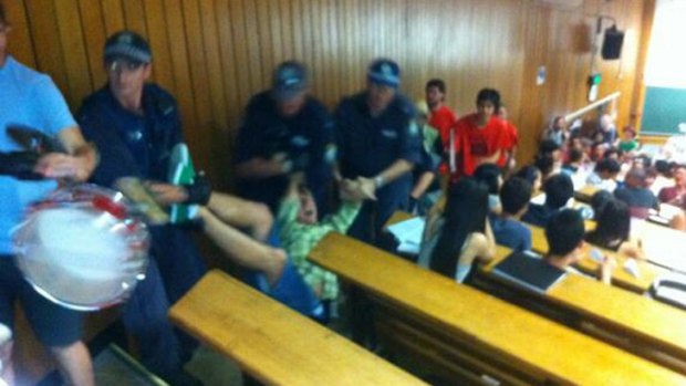 Dispute over a collective agreement: A University of Sydney student is dragged from the lecture hall by police.
