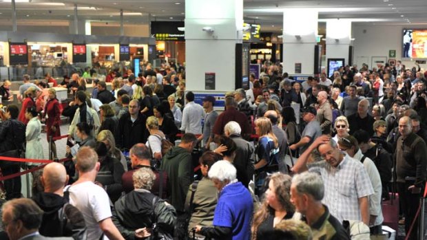 Getting in the line ... travellers seeking to secure air seats to their destination join the long queues yesterday at Virgin Australia check-in counters at Melbourne airport.