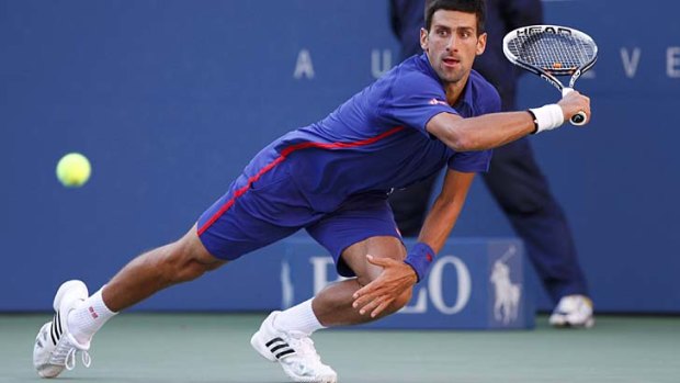 Serbia's Novak Djokovic falls as he attempts a return.