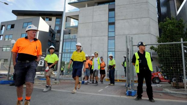 CFMEU Secretary Dean Hall (right) stands at the Aurora apartments this morning as workers are ordered off the site, so a safety inspection can take place.