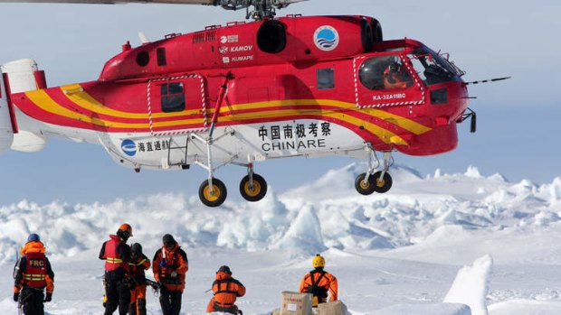 A Chinese helicopter lands on an ice floe next to the Aurora Australis during the Akademik Shokalskiy rescue operation.