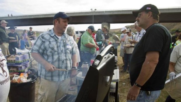Dave Bundy (L), a son of rancher Cliven Bundy, cooks hamburgers during a Bundy family "Patriot Party" near Bunkerville.