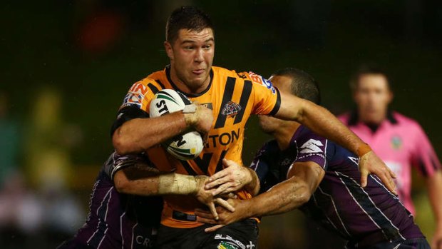 Slippery customer: Melbourne Storm players tackle Tigers five-eighth Curtis Sironen.