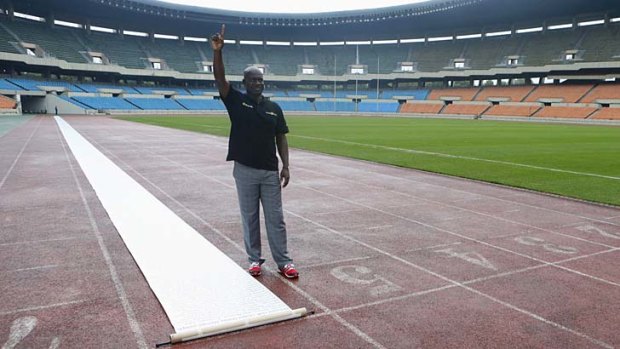 Sprinter Ben Johnson of Canada poses after running next to a petition laid out on the track at the Seoul Olympic Stadium on Tuesday.