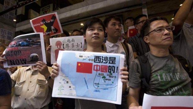 Anti-Vietnam protesters hold posters with slogans and a picture showing a map of the South China Sea during a protest defending China's territory claim.