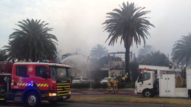 Firefighters douse the burning restaurant with water.