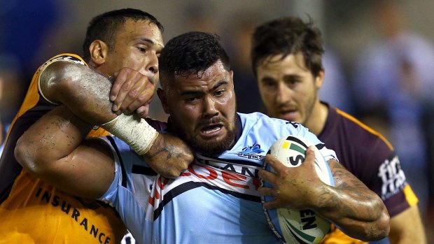 Shark net: Cronulla's David Fifita is wrapped up by Justin Hodges.