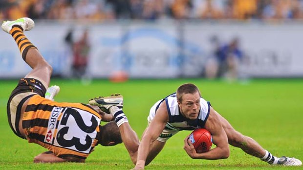 On the deck . . . Hawthorn star Lance Franklin attempts to grab hold of Geelong player David Wojcinski at the MCG yesterday.
