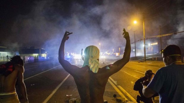 Protesters face off with police after tear gas was fired at crowds in Ferguson, Missouri, on Sunday.
