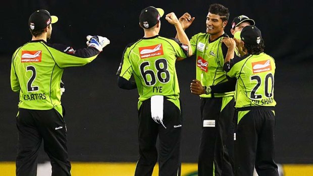 Sydney Thunder's Gurinder Sandhu celebrates after taking a catch off his own bowling to dismiss Peter Nevill of the Renegades.