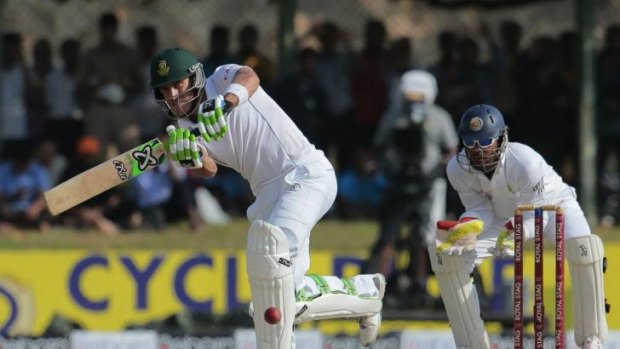 Faf du Plessis  is watched by Dinesh Chandimal.
