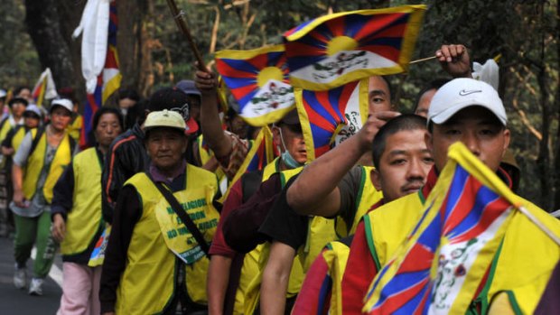 Silent protest ... monks and members of the Tibetan Youth Congress wave flags as they walk past Mahananda Wildlife Sanctuary at Sevok.