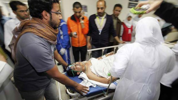 Under fire ... an injured protester is rushed to the operating theatre in a Manama hospital.