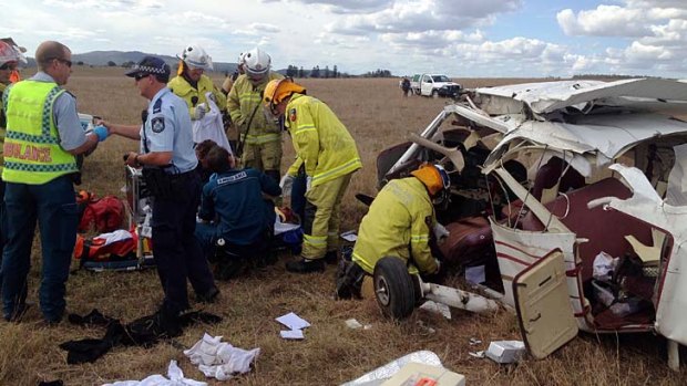 Emergency workers surround the wreckage of a plane that crashed at Beaudesert.