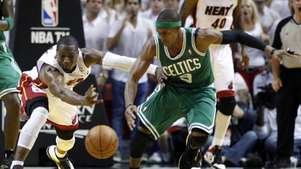 Miami Heat's Dwyane Wade (left) fights for a loose ball with Boston Celtics' Rajon Rondo.