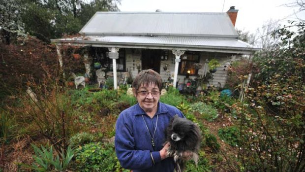 Decay and rot: Camilla Groves and one of her dogs in front of her crumbling home.