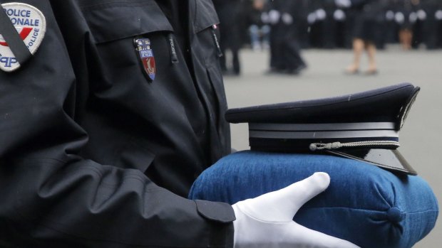 A French police officer holds the hat of late police officer Ahmed Merabet. Police officers Merabet, 40, and Franck Brinsolaro, 49, were killed during the attacks at Charlie Hebdo, while Clarissa Jean-Philippe was killed in Montrouge last week.  