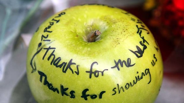 An apple with tributes written on it forms part of a memorial for Steve Jobs in Boston.