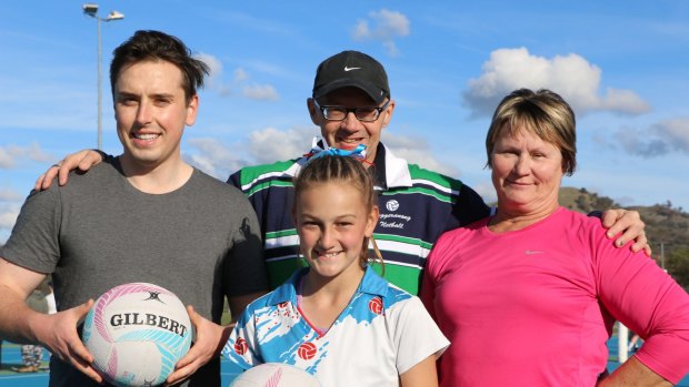 Michael Pettersson, left, and Nicole Lawder, right, received netball skills training at the Calwell netball courts  as part of their preparation for TNA Turns Pink 3 charity event on June 17 , from Tuggeranong Netball's head coach, Matt Hills, centre, watched on by Nicole's grand-daughter, Annabelle Adcock, who plays for the Rebels Netball Club and represents Tuggeranong in junior representative netball.
